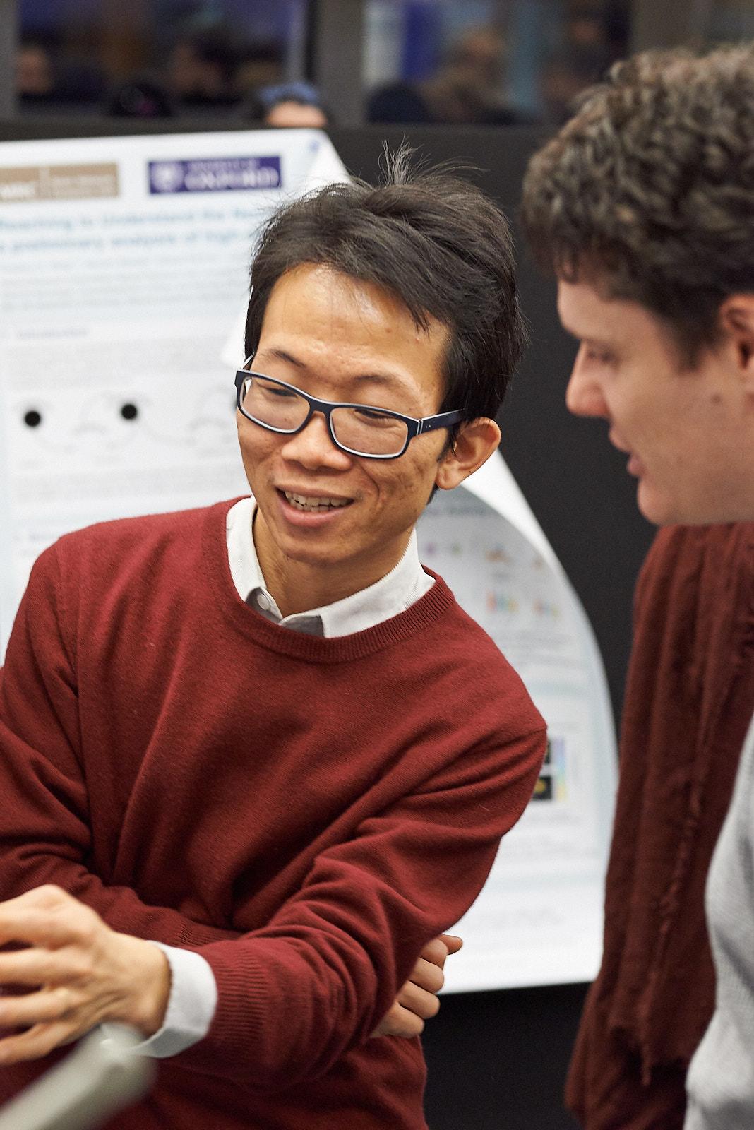 A photo of Shenghong He and Unit colleagues talking at winter Science Day 2022.
