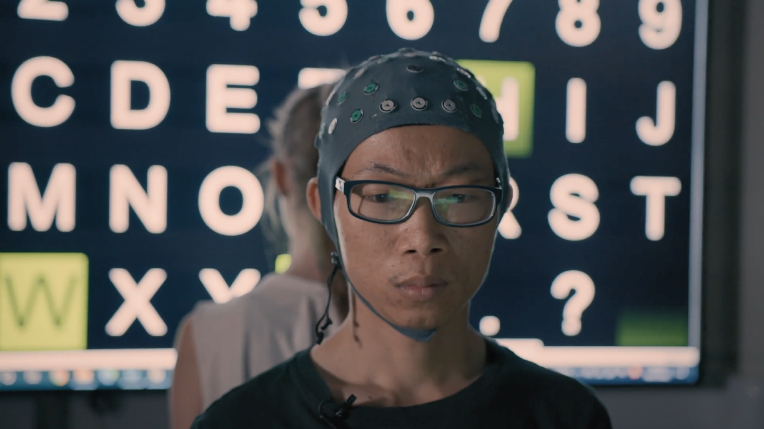 A screen shot from the video The Symphony of the Brain showing Unit researchers Shenghong He (foreground) and Demi Brizee (background